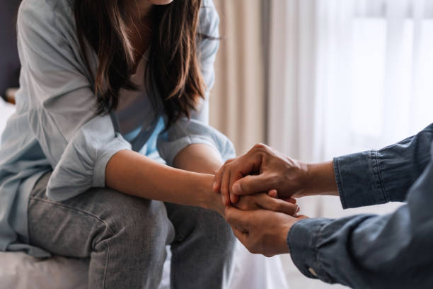 Young man comforting and supporting a sad woman who is in serious trouble at home, Consolation and encouragement concept